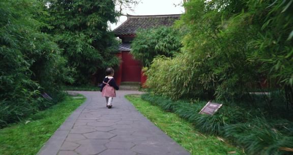 小女孩在公园小道上走路玩耍