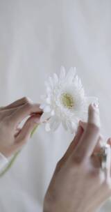 一个女人用手在剥花的花瓣竖屏