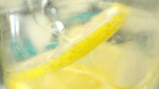 黄色的柠檬水加冰块特写镜头慢动作