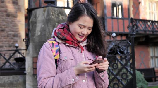 年轻女子在伦敦街头使用手机