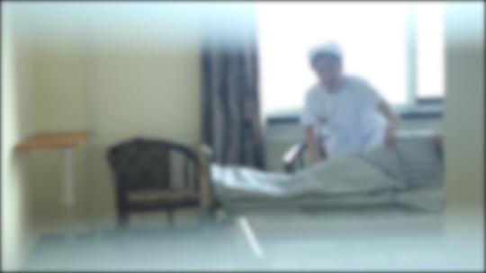 病房内医护人员整理床褥照顾病人盖被子