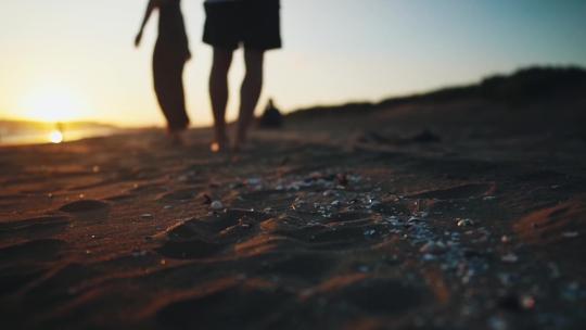 海边夕阳男女沙滩散步约会