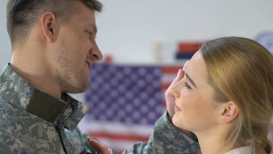 可爱的美国士兵拥抱年轻的妻子看相机视频素材模板下载
