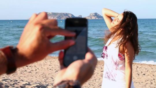 2116_一个男人在海滩上给他的女朋友拍照
