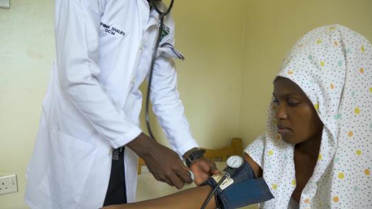 非洲医生用听诊器检查病人的血压和心跳。