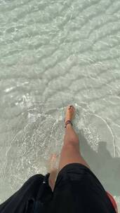 在清澈海水中行走的腿部特写