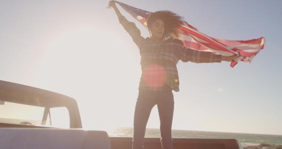 一名女子站在一辆皮卡上挥舞着美国国旗4k
