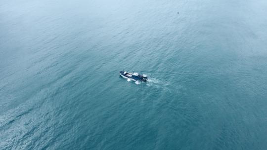 航拍在蓝色海面上航行着的渔船