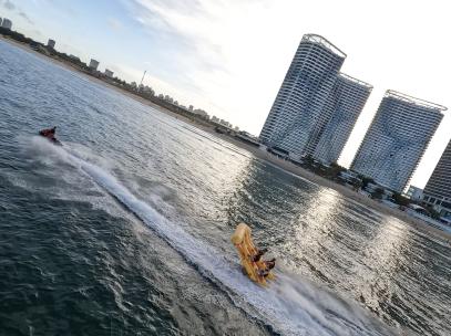 fpv穿越机航拍大海边海上摩托艇拖拽香蕉船