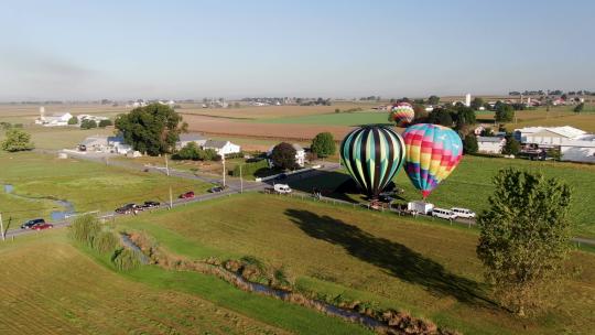 广角空中转弯拍摄显示热气球降落在兰开斯特县的草地上