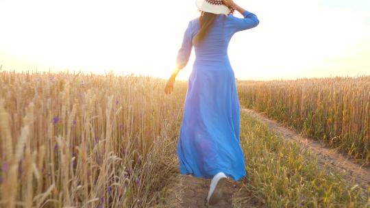 穿着连衣裙的女人跑在田野上
