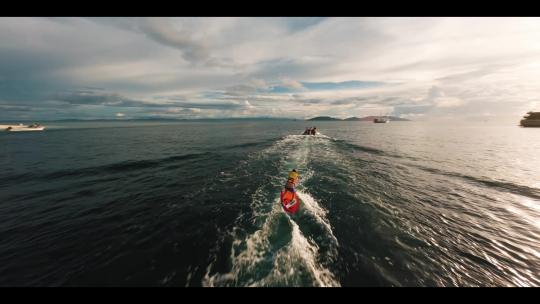 FPV航拍快艇拉着少年玩水上滑板日出四王岛