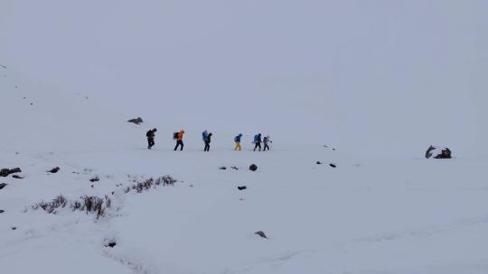 攀登岷山山脉都日峰的登山者在雪中徒步行进