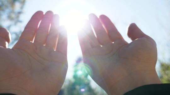 一个人举手向天空祈祷