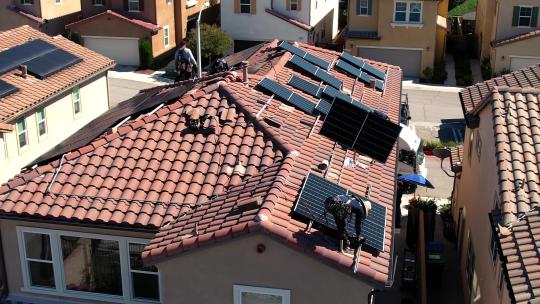 几个人在房顶安装太阳能电池板