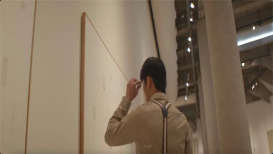 4K 艺术展厅男子看书思考抬头光影视频素材模板下载