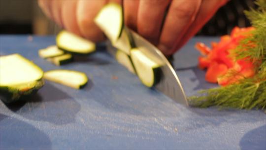 在桌子上切好的番茄堆上用刀切西葫芦视频素材模板下载