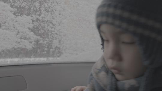 小孩坐在车里看窗外大雪slog