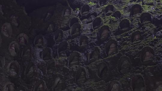 阴暗潮湿石壁上的佛像千佛洞