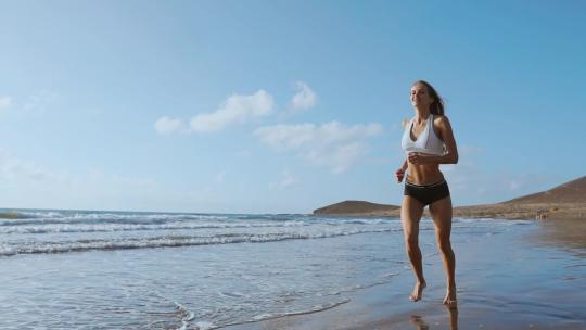 健康女性在海滩上跑步