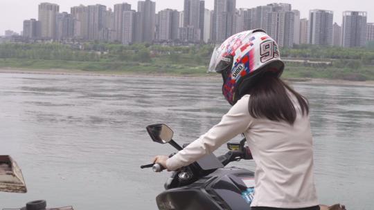 一名女骑手骑机车来到江边