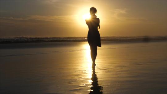 日落时分女人在海滩上散步