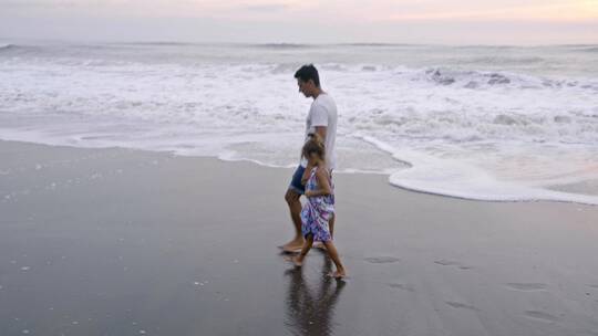 爸爸和女儿在海边散步