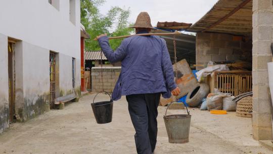 农村老人传统取水扁担水桶挑水背影特写视频素材模板下载
