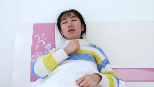 感冒生病发烧咳嗽气喘躺床上的女人