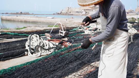 渔民在织网补网