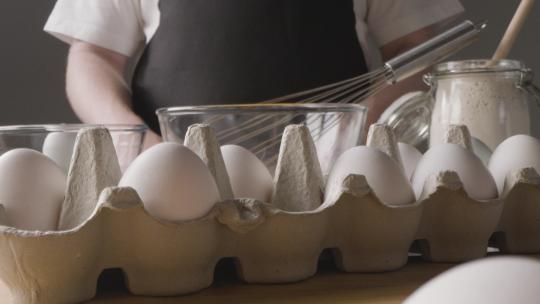生鸡蛋在一个玻璃碗里搅拌