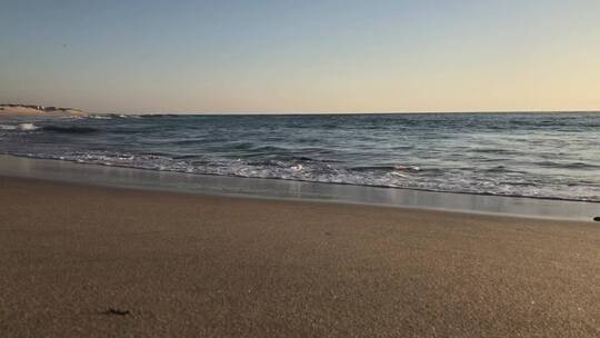 平静的海浪拍打在海滩上