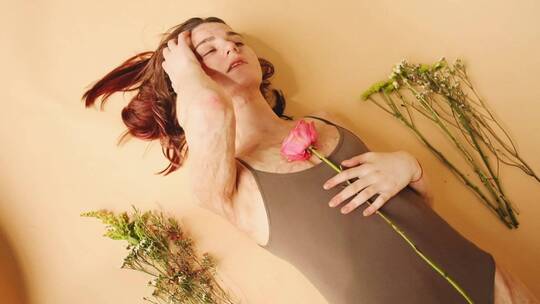 一个女人躺在花的旁边