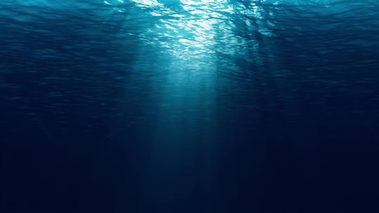水下光线穿过深蓝色的海浪