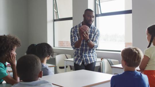 生物课上快乐的非裔美国男老师和不同学生班级的视频