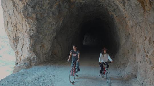 一对情侣骑自行车穿过山洞