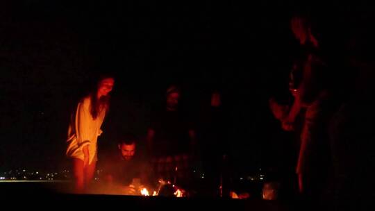 男人和女人晚上聚在篝火旁