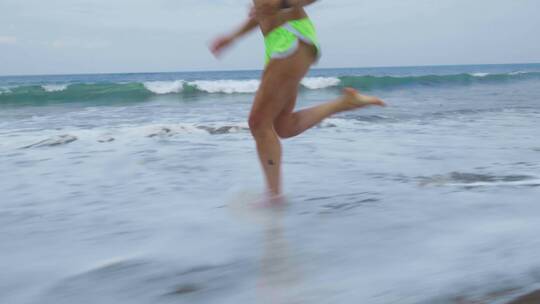 一个女人赤脚在沙滩上跑步