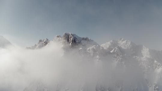 巍峨山峰山脉山峦航拍阳光下的雪山云雾迷雾