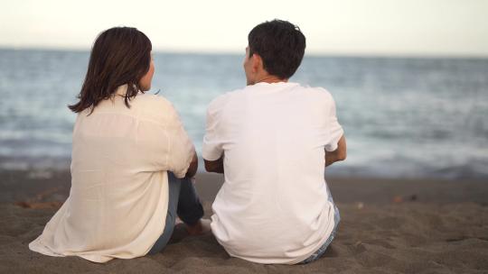 一对夫妇坐在海滩上聊天