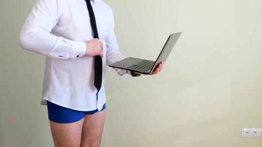 穿着内裤的男人通过笔记本电脑与人对话