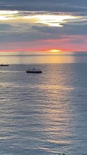 夕阳下海上小船的剪影