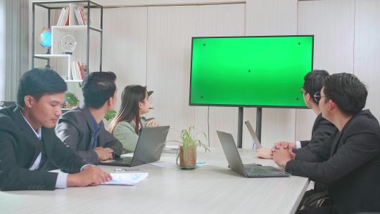团队在有电视绿屏的会议室开会