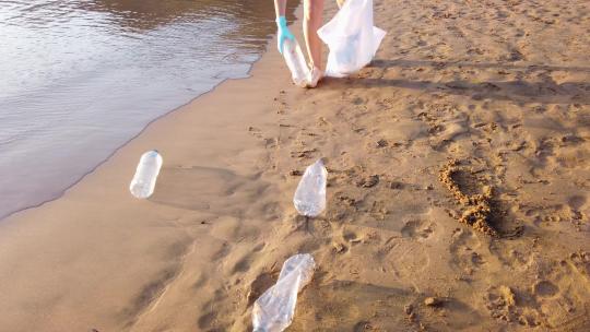 海滩上捡瓶子的女人视频素材模板下载