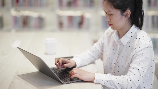 职业女性在办公室内笔记本电脑上工作