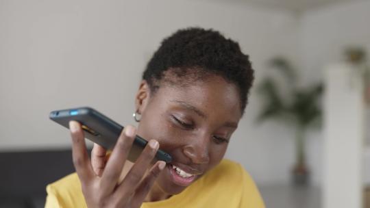 年轻的非裔美国妇女在家用手机录制音频信息视频素材模板下载