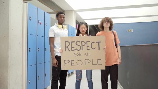 学生举着写着尊重所有人的横幅