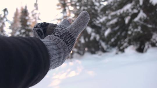 带着手套在白雪的风景中抓太阳