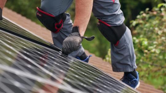 工人在屋顶上安装太阳能电池板