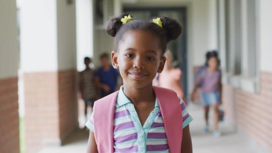 快乐的非裔美国女孩站在学校走廊的视频视频素材模板下载
